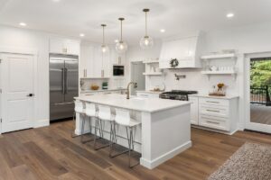 Beautiful white kitchen with island, gas range, hood, vinyl plank flooring in Doylestown pa.